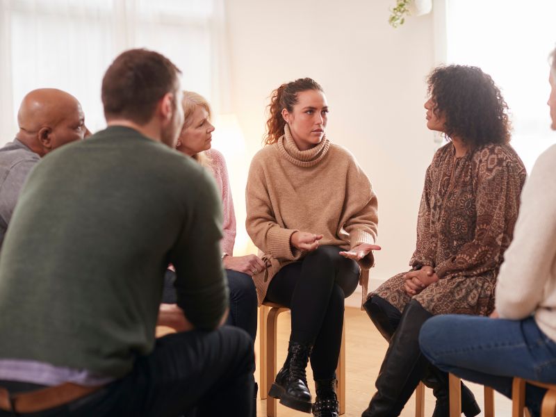 People seated in a circle during a facilitated group discussion.
