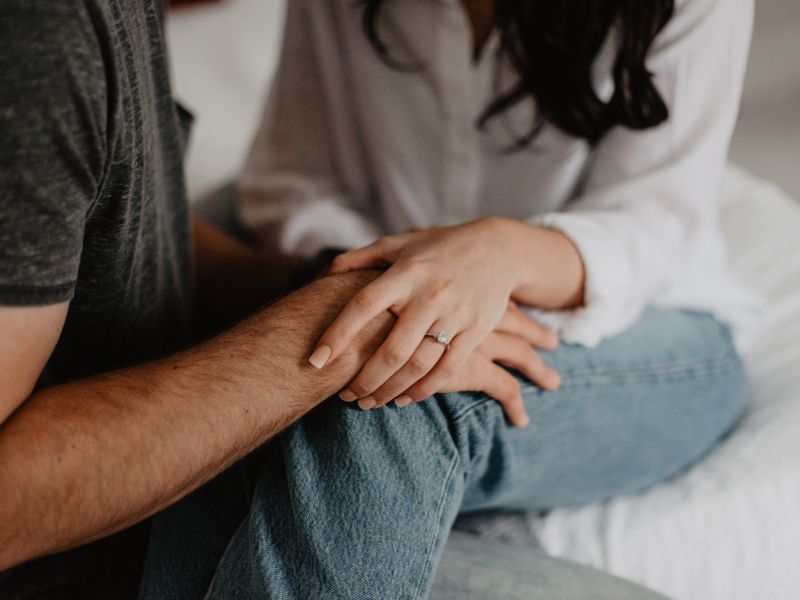 Partners holding hands during a supportive conversation.