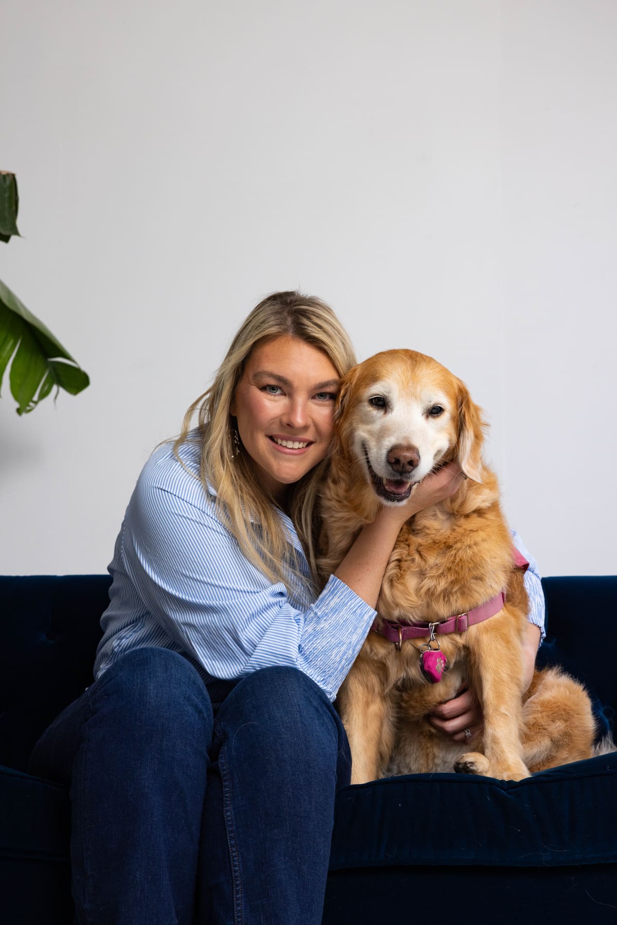 Hannah Snider smiling beside Lola, the practice's golden retriever.